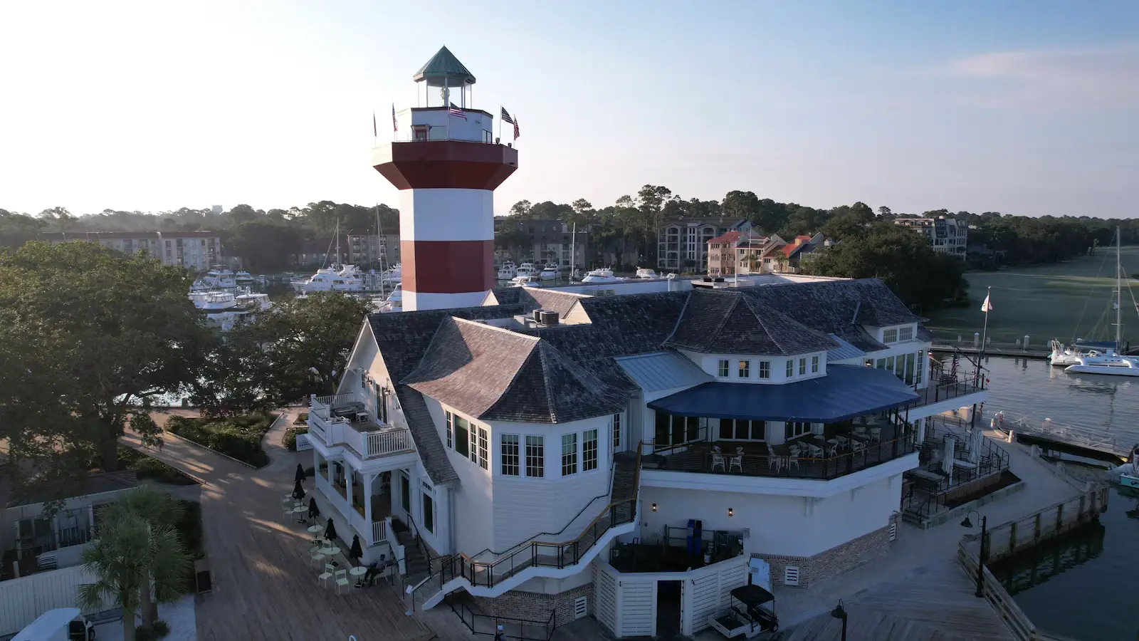 A lighthouse rising above a harbour-side building at the water's edge